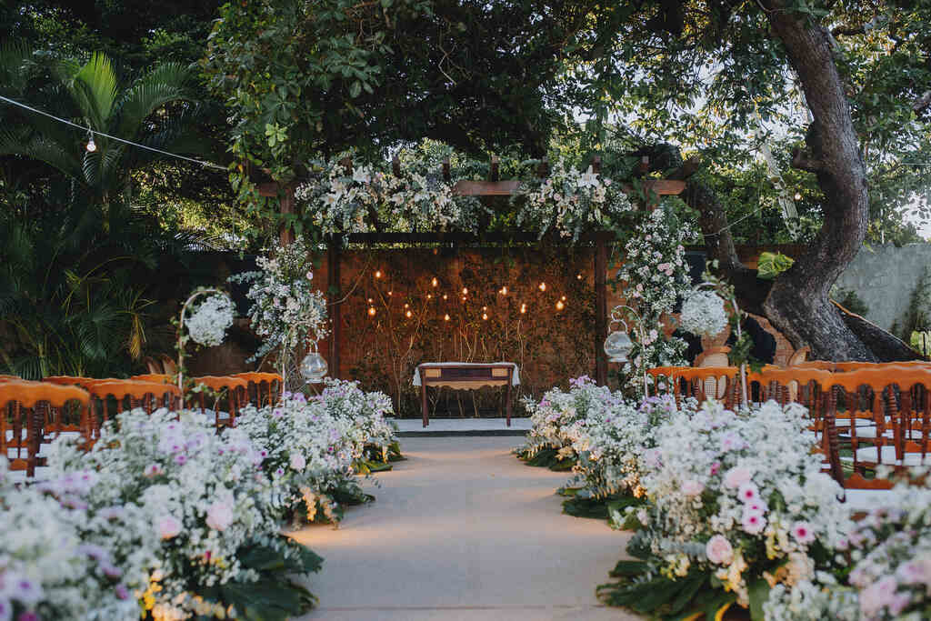 altar e caminho da noiva decorado com flores brancas e rosas claras