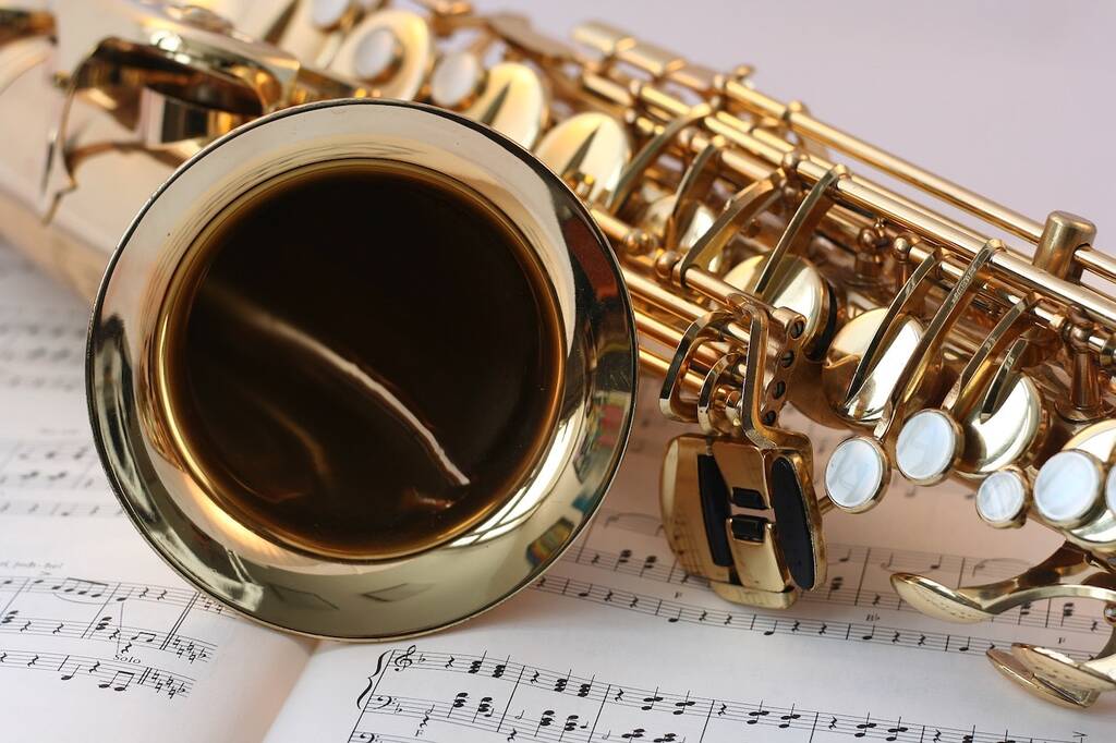 saxofone em cima de livro de partituras