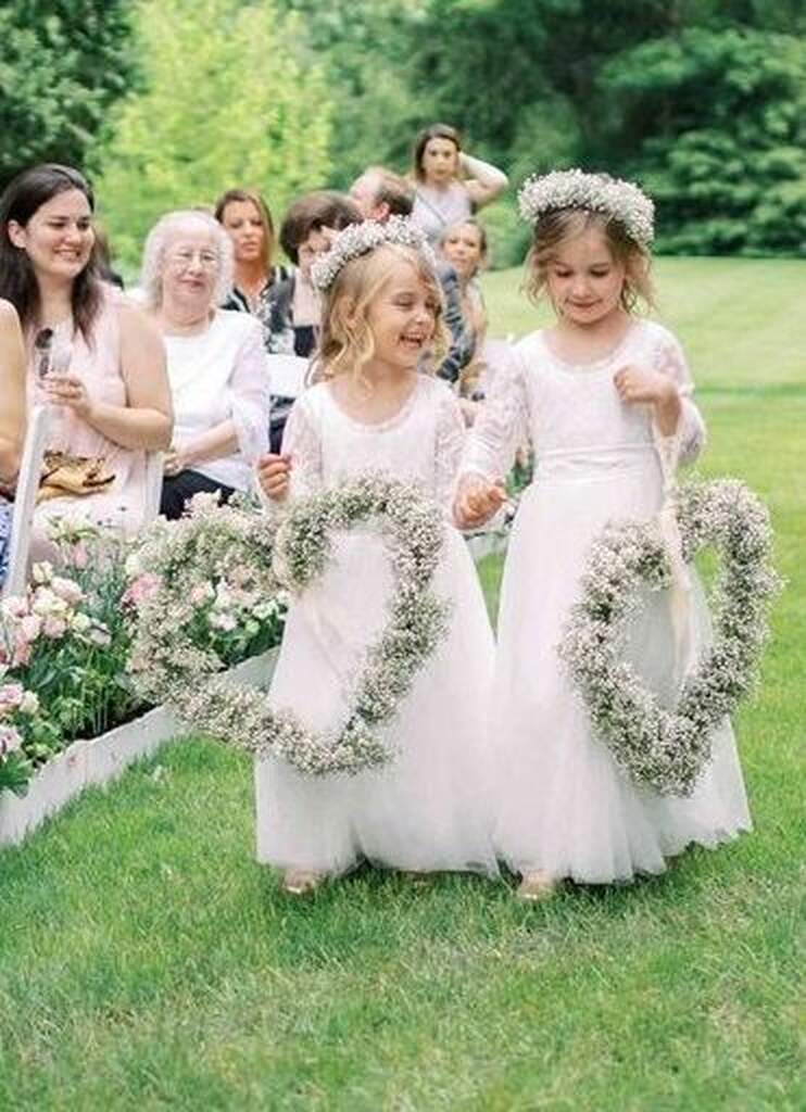 floristas de casamento entrando com guirlanda em formato de coração com flores mosquitinho