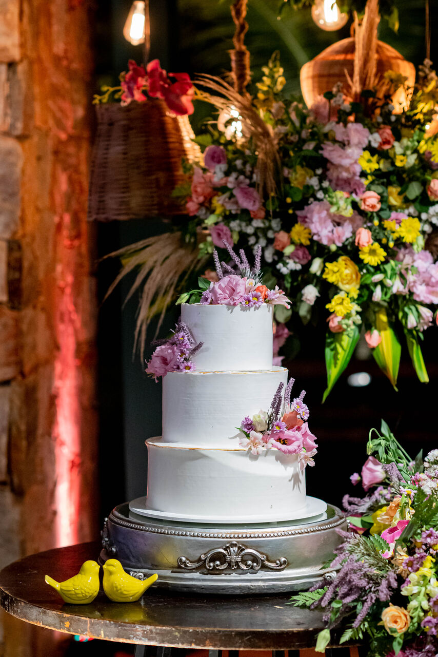 bolo de casamento branco com três andares com flores rosas e lavandas