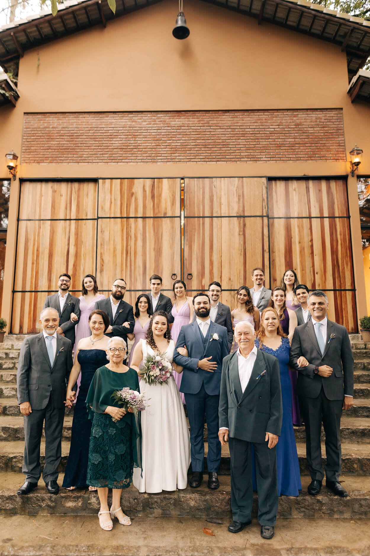 pais madrinhas e padrinhos ao lado dos noivos na escada