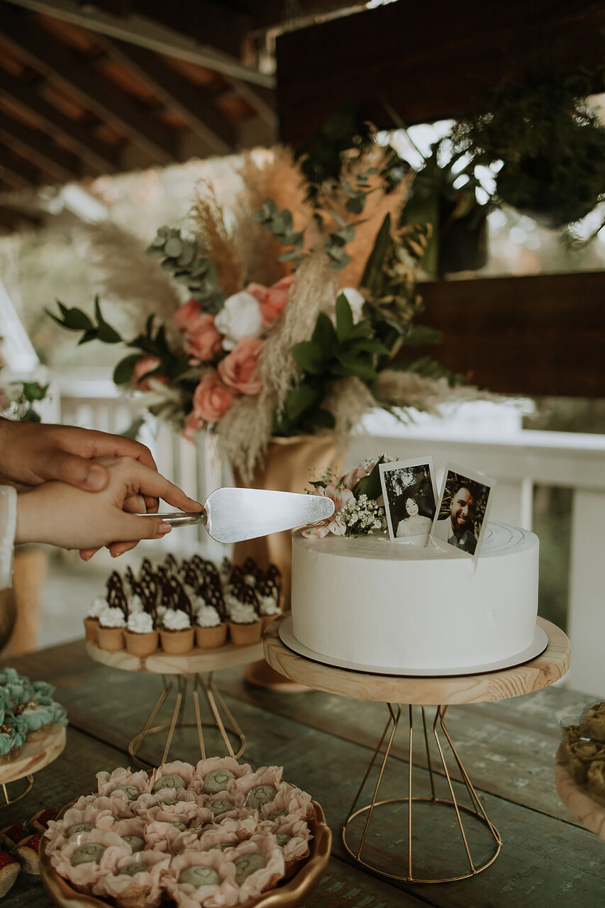 bolo de casamento branco com fotos de polaroide no casal no topo