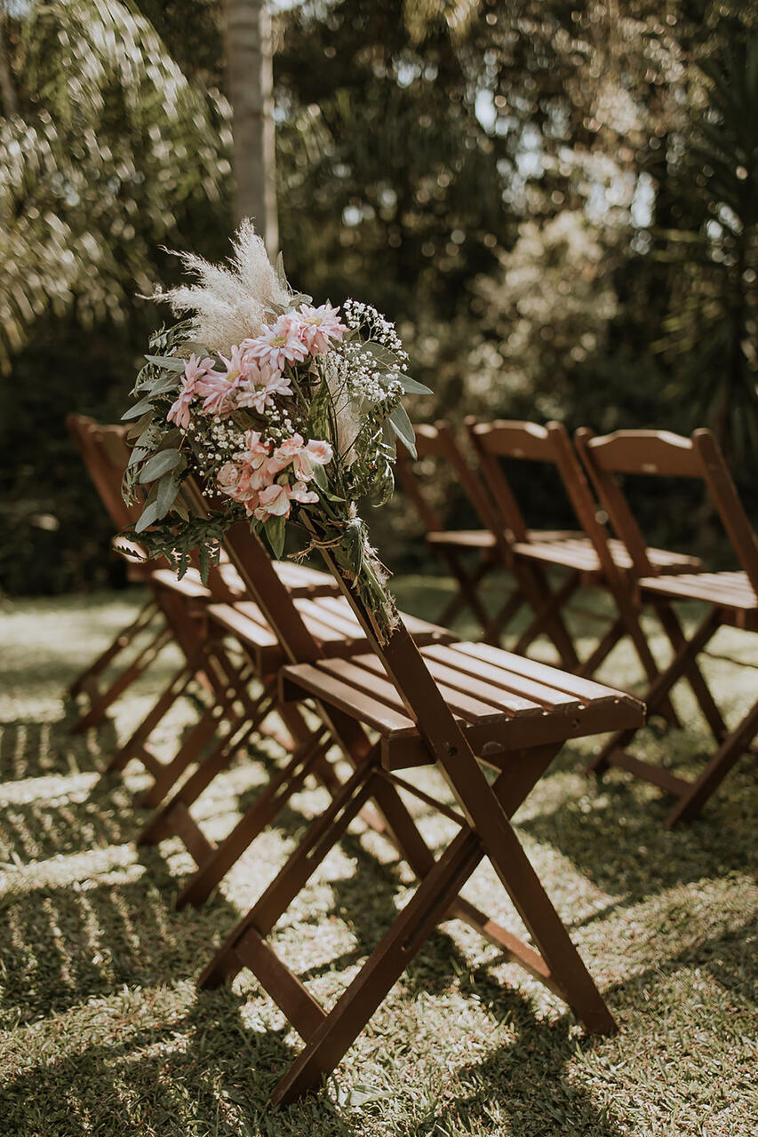 cadeiras de madeira simples decoradas com flores rosas