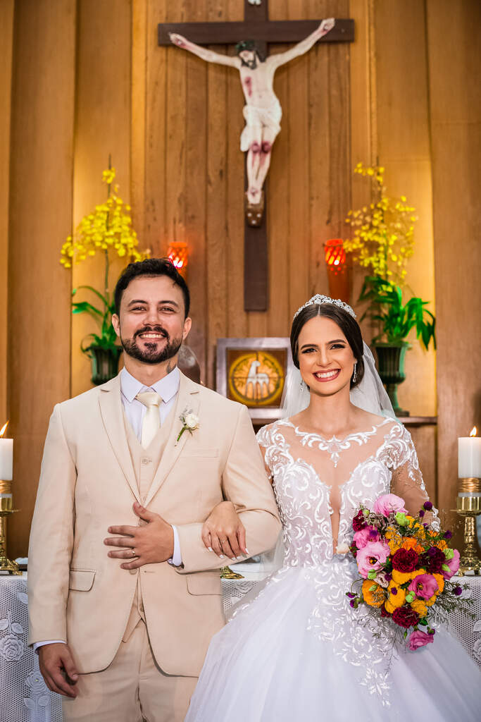noivos sorrindo na frente do altar na igreja