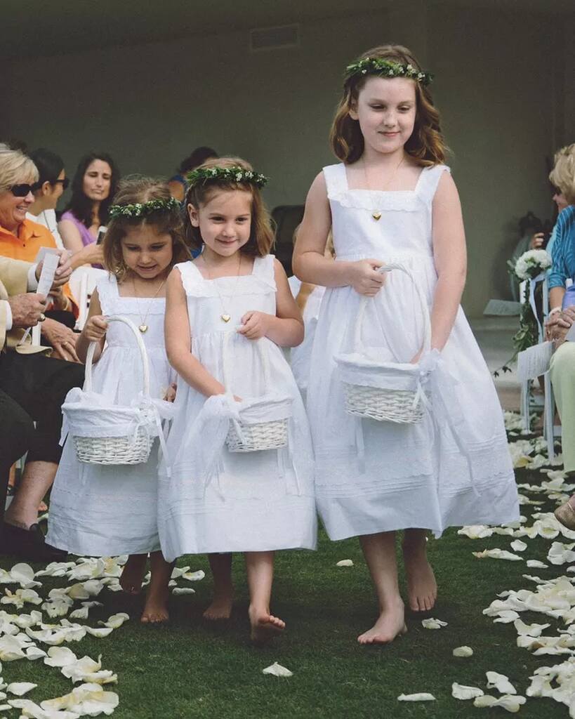 floristas de casamento entrando em cerimônia com cestas brancas