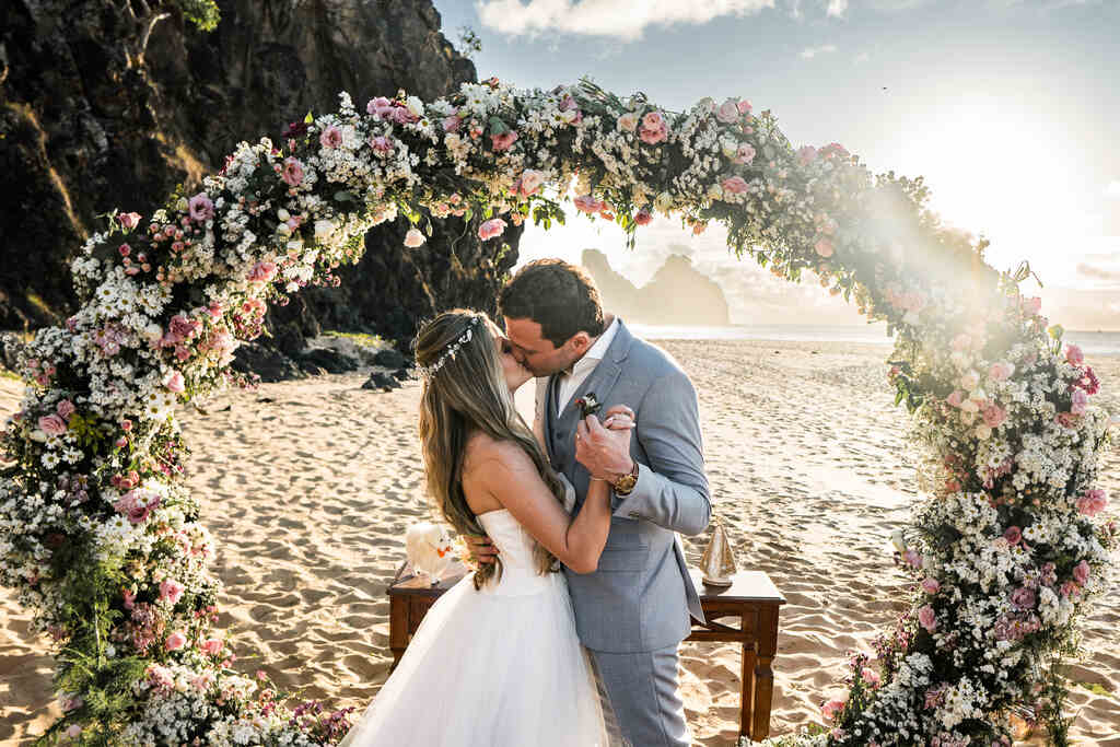 noivos se beijando no altar na praia