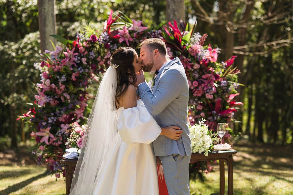 noivos se beijando no casamento ao ar livre