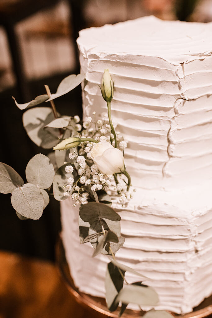 bolo de casamento octagonal espatulado com flores brancas no topo