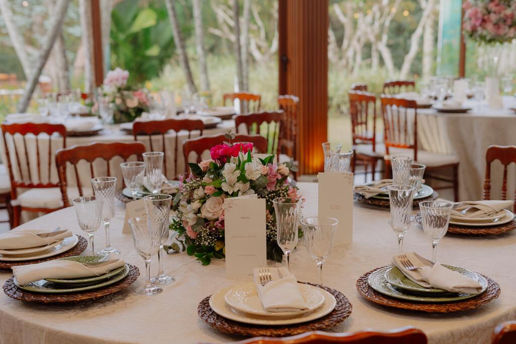mesa posta redonda branca com arranjo com flores brancas e rosas 