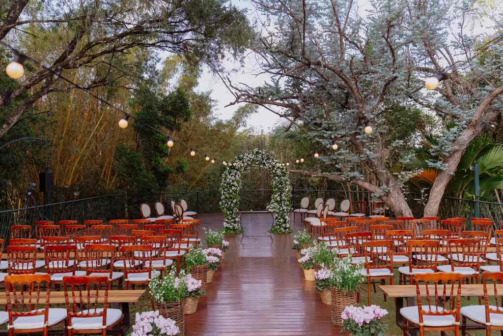 cadeiras de madeira sob deck e altar com flores brancas no altar
