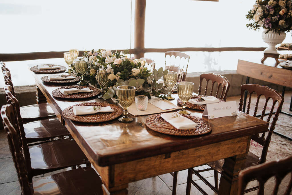 mesa de madeira com mesa posta com flores brancas no centro