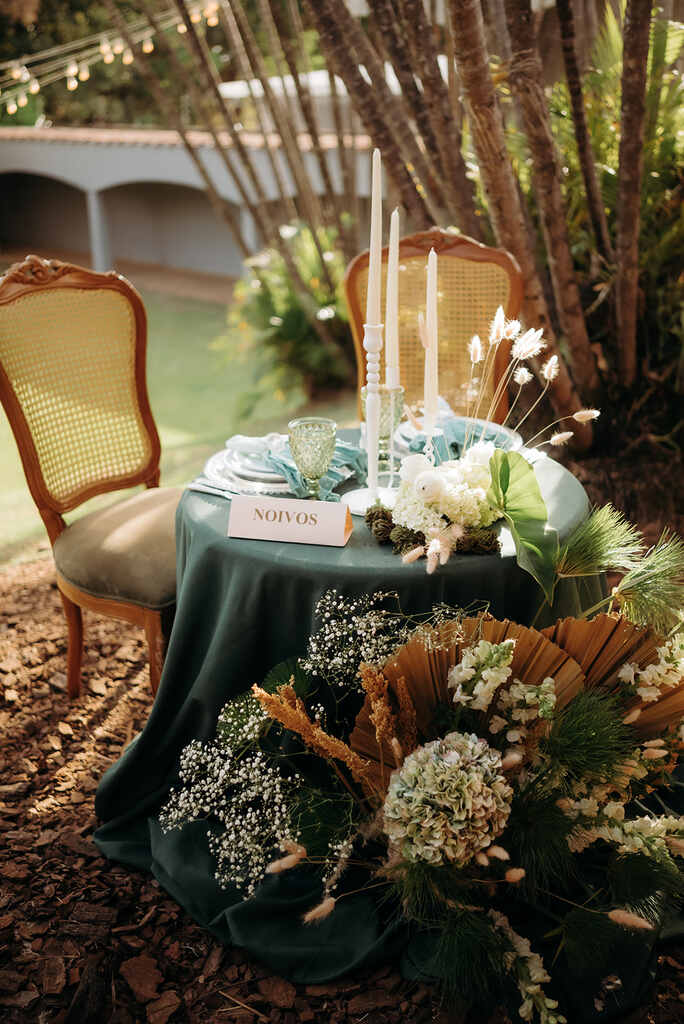 mesa dos noivos com toalha verde com velas brancas