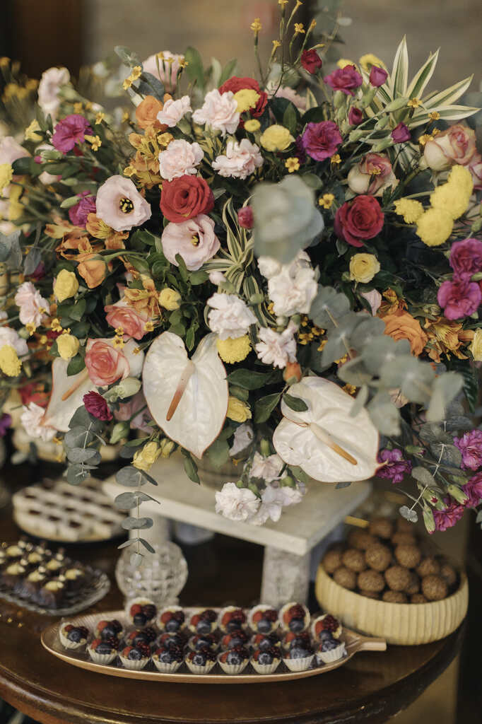 mesa com arranjos de flores coloridas