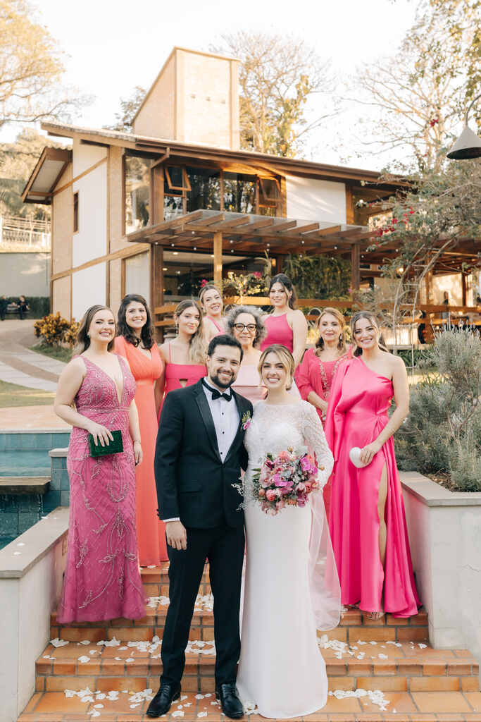 noivos e madrinhas com vestidos cor de rosa ao fundo
