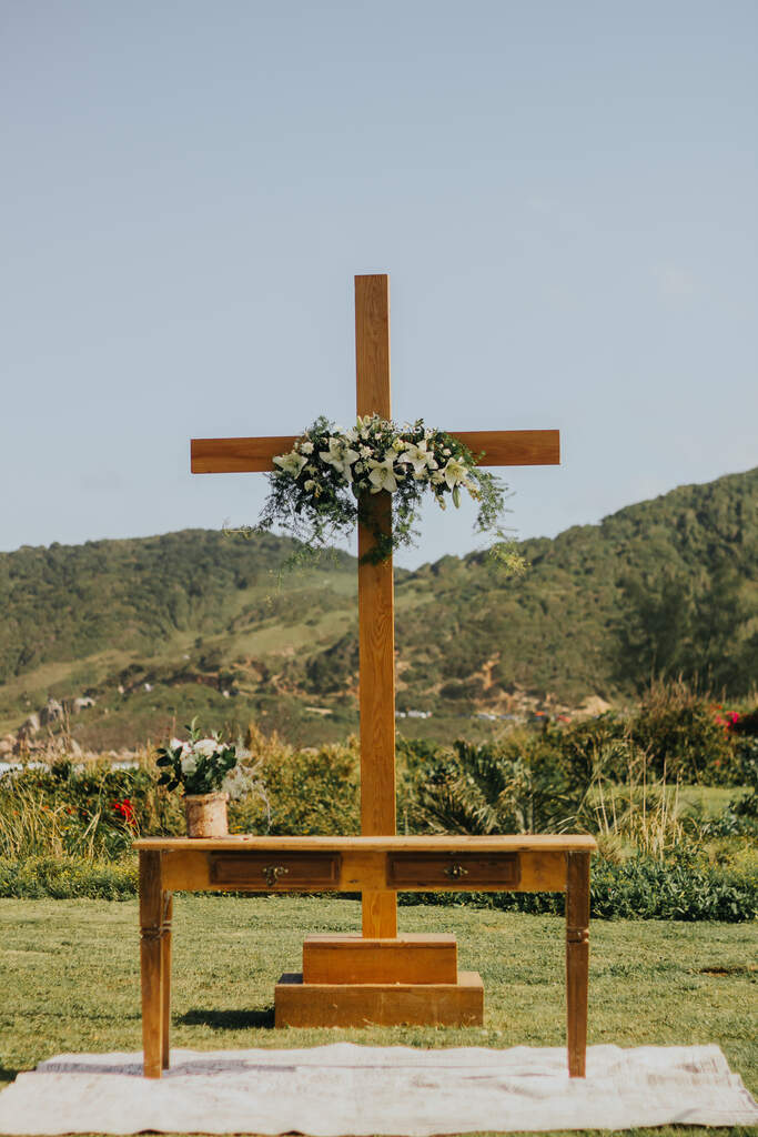 altar de cruz de madeira com lírios brancos