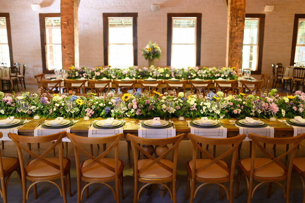 mesas postas com flores coloridas no centro