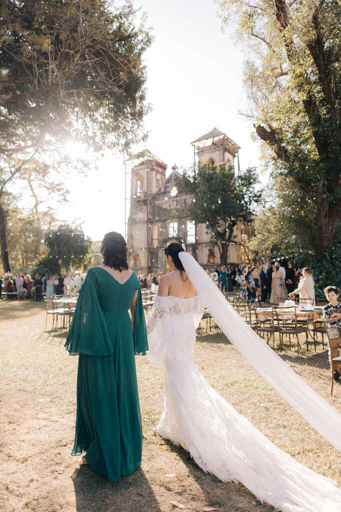 entrada da noiva ao lado da madrinha com vestido verde