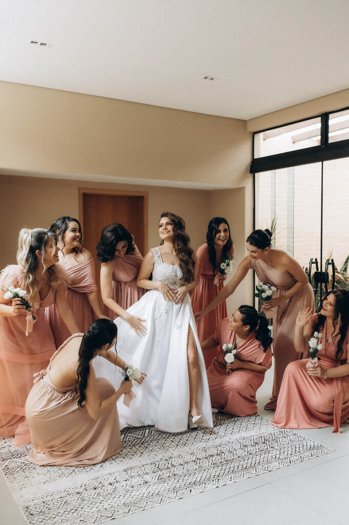 noiva e madrinhas com vestidos cor de rosa dentro da sala