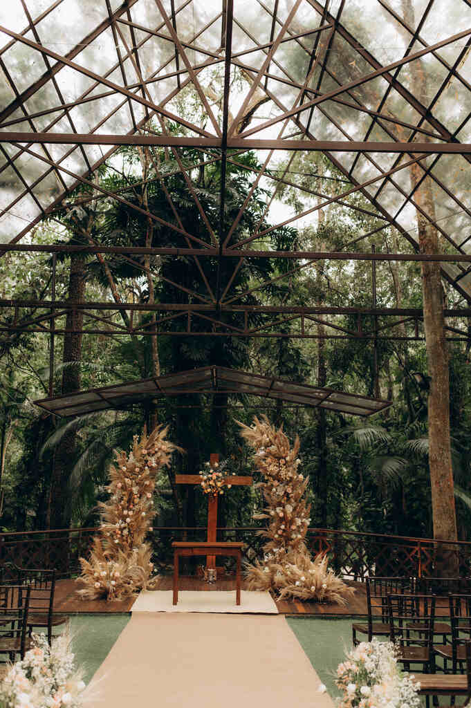 altar com cruz de madeira e arranjos com capim dos pampas ao ar livre