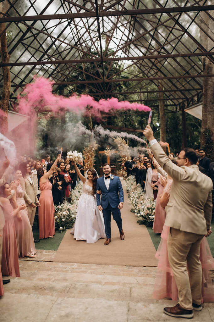 saída dos noivos sob fumaça cor de rosa e branca