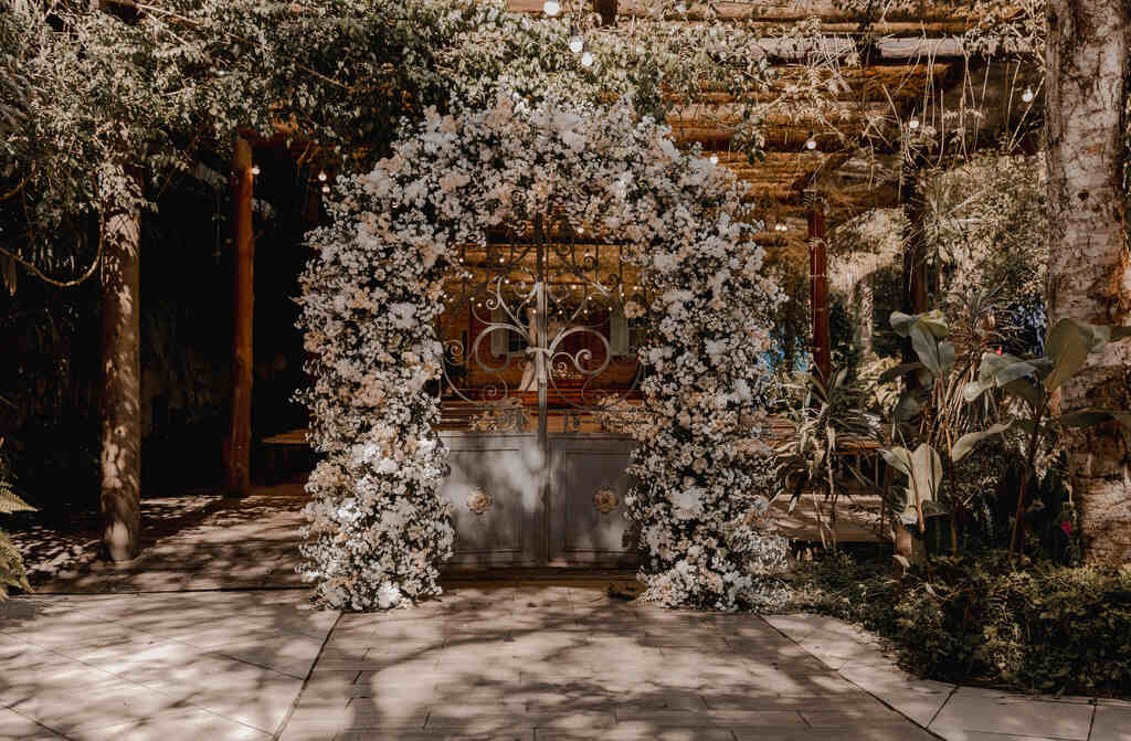 portão antigo cinza com flores brancas e rosas