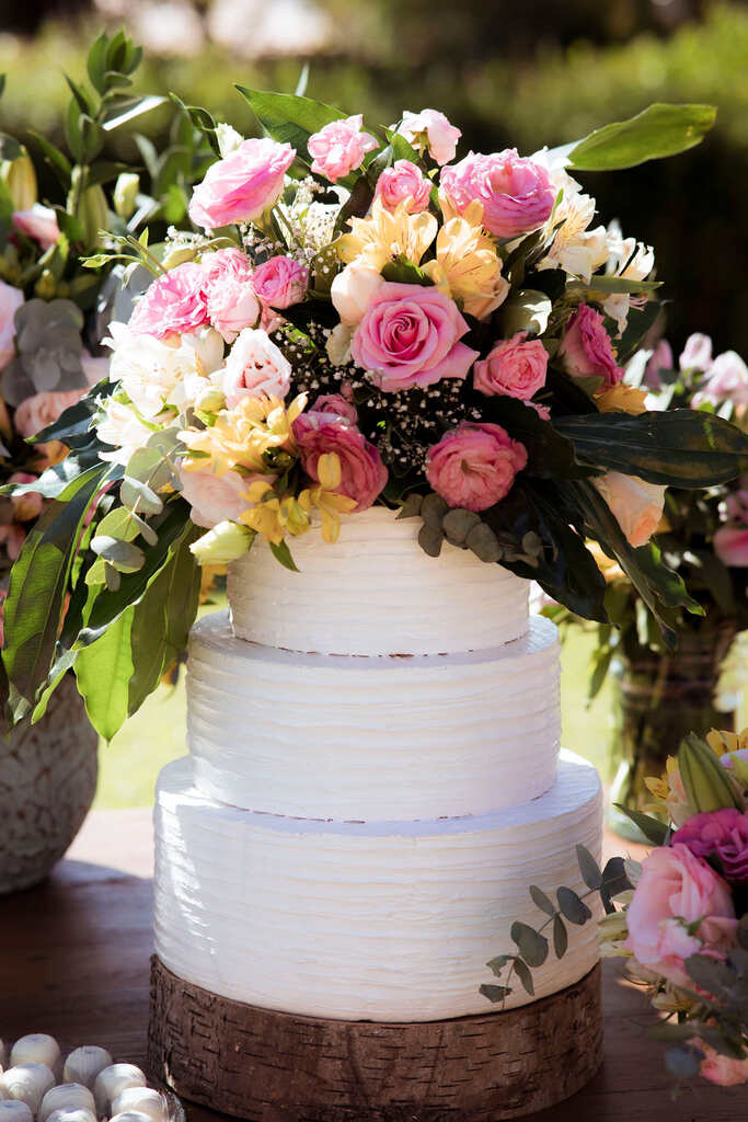 bolo de casamento branoc com três andares com topo de flores amarelas e rosas