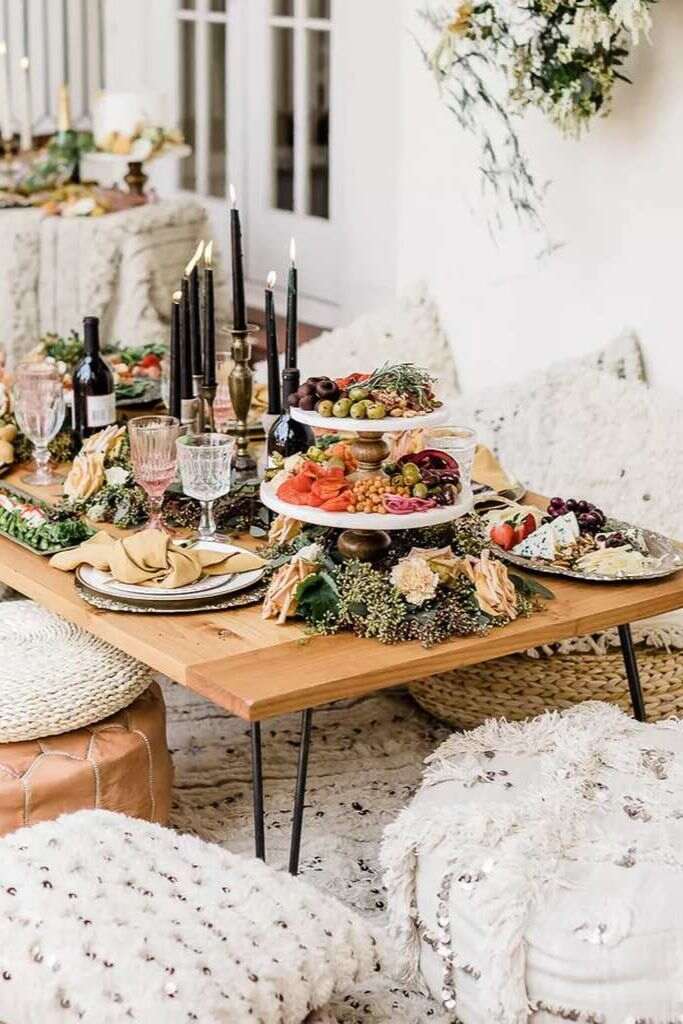 mesa com brunch com velas pretas e garrafas de vinho