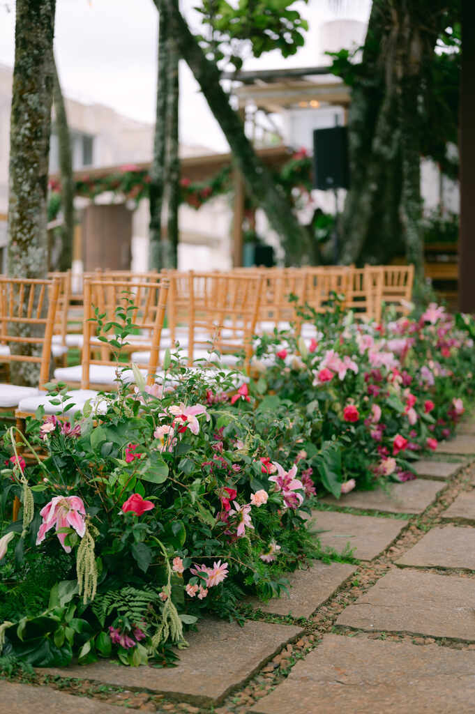 cadeiras de madeira com assentos brancos decorados com plantas e flores rosas