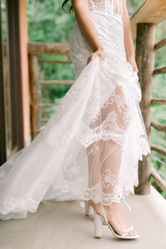 Noiva segurando véu de casamento rendado na varanda