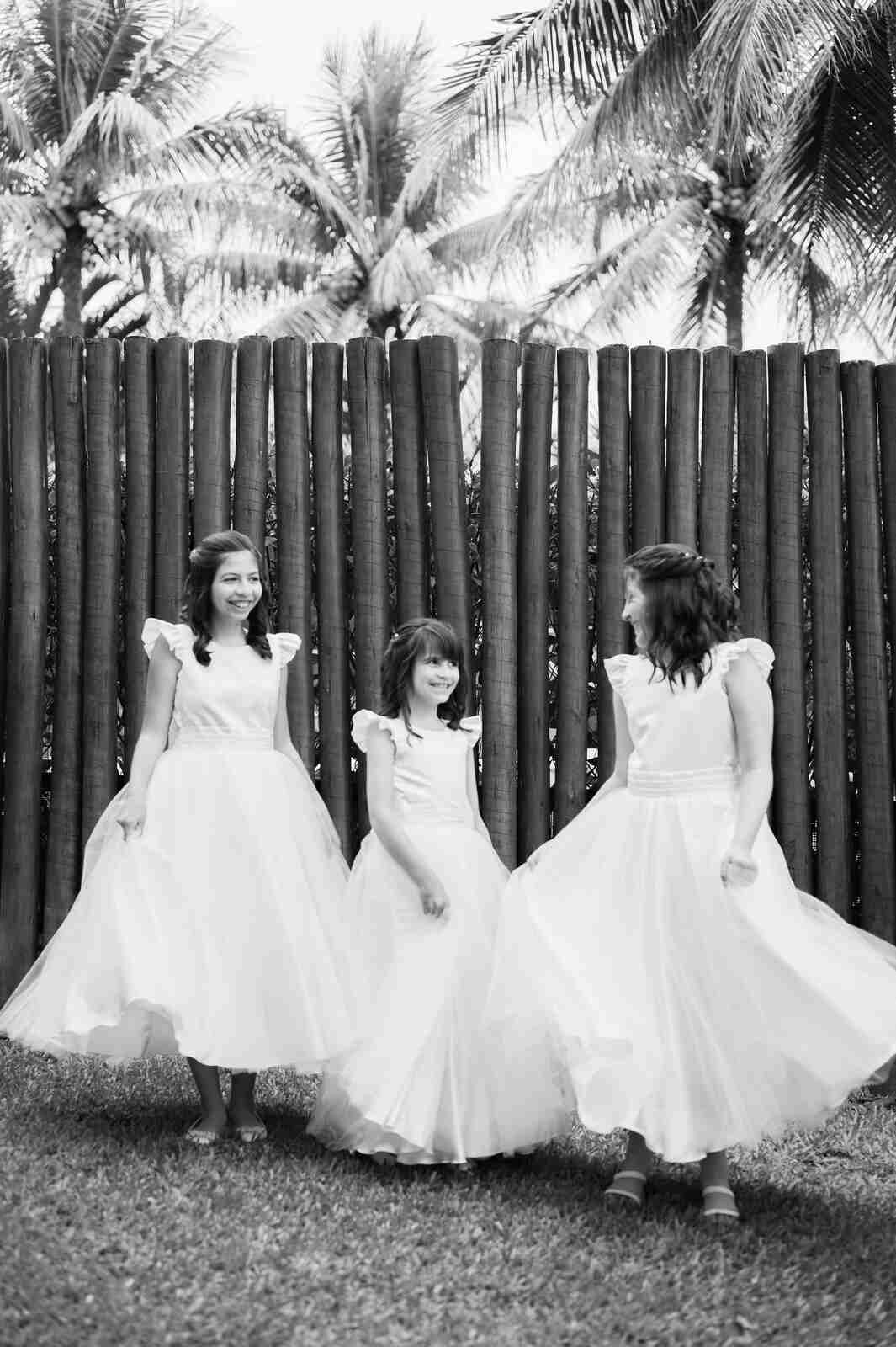três meninas com vestidos para daminhas no jardim