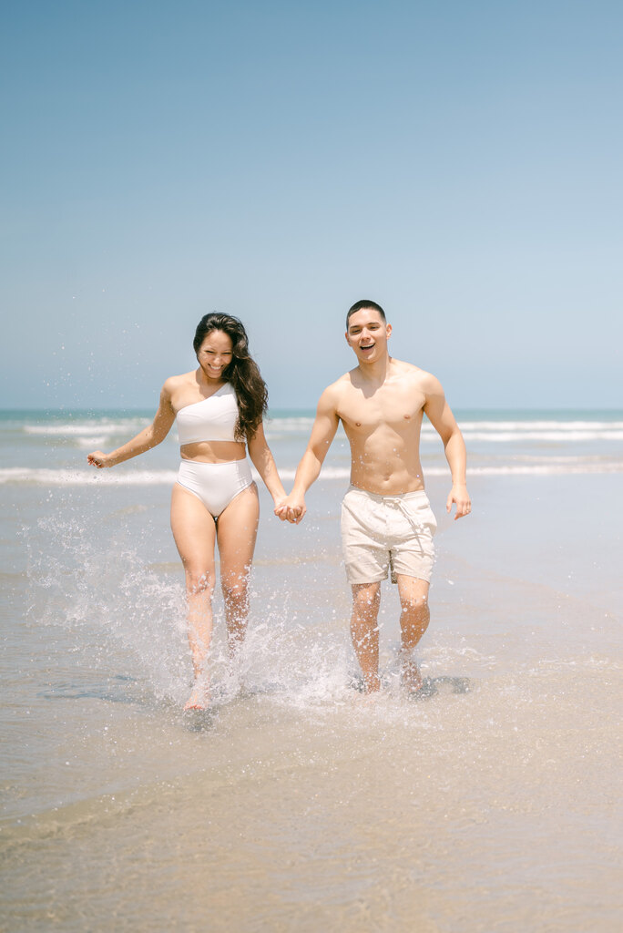 casal correndo na beira da praia