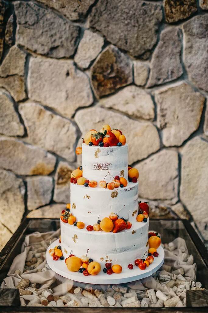 bolo d ecasamento branco semi espatulado com três andares com frutas cítricas no topo