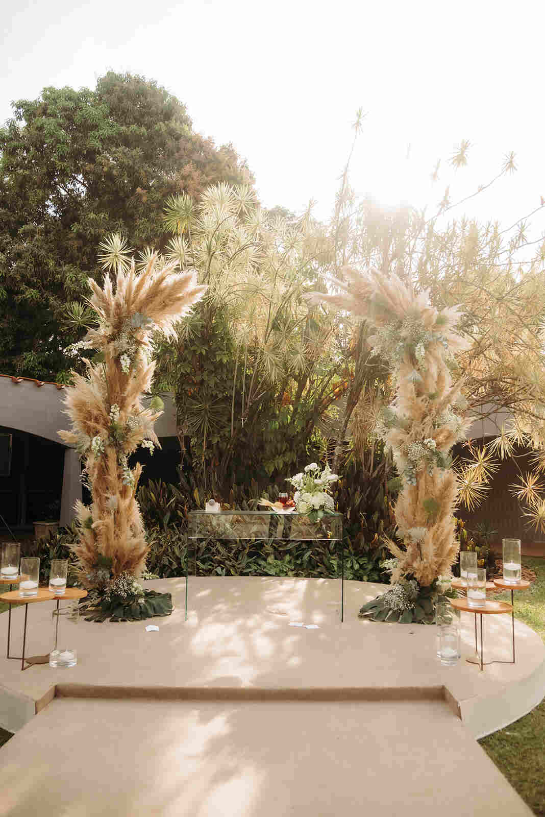 altar com capim dos pampas e mesa de vidro com flores brancas