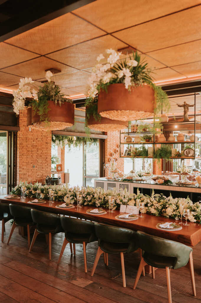salão rústico com mesa posta decorada com flores brancas no centro