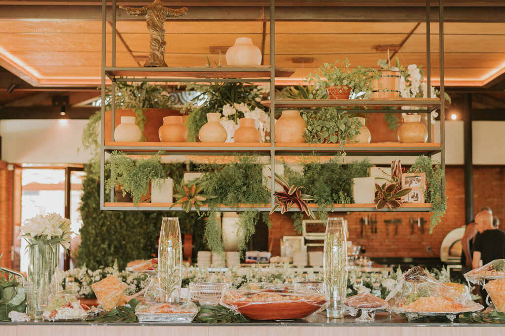 bancada decorada com vasos de vidros e outros de barro e plantas