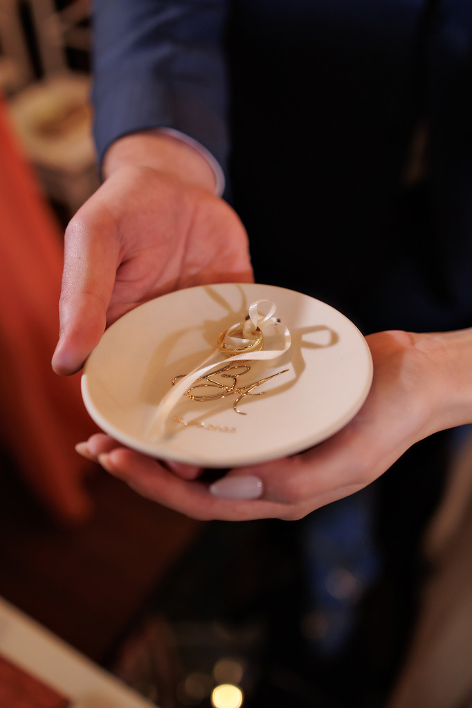 noivos segurando prato de porcelana como porta alianças