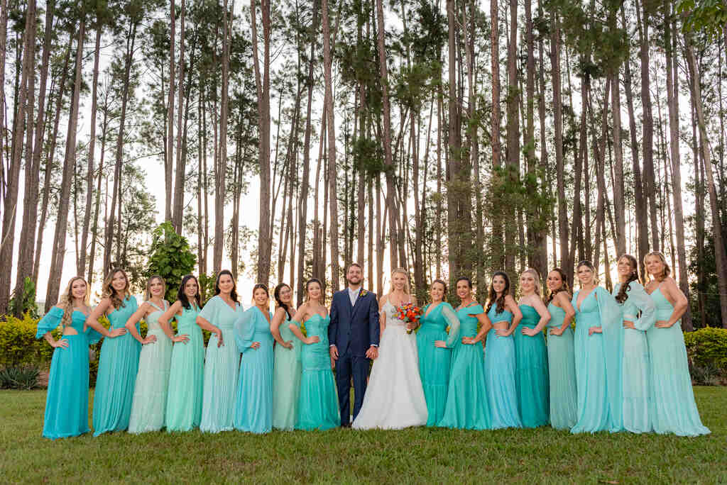 noivos ao lado das madrinhas com vestidos azuis na cor tiffany no campo