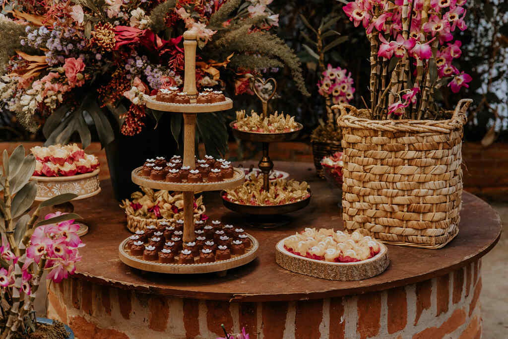mesa de madeira marrom com bandejas redondas com doces de casamento