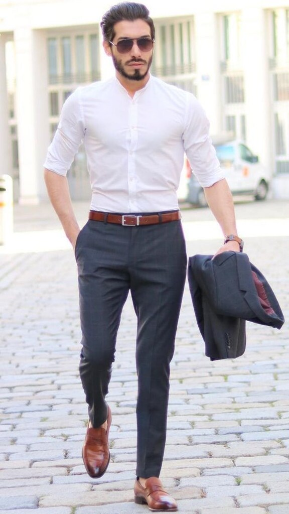 homem com camisa branca calça preta justa e cinto marrom andando na cidade