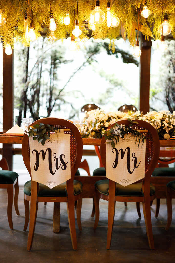 cadeiras de madeira com bandeirolas escrito mr e mrs