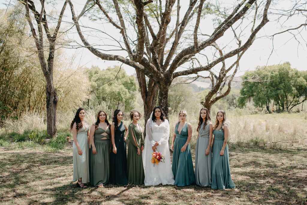noiva ao lado das madrinhas com vestidos verdes embaixo da árvore