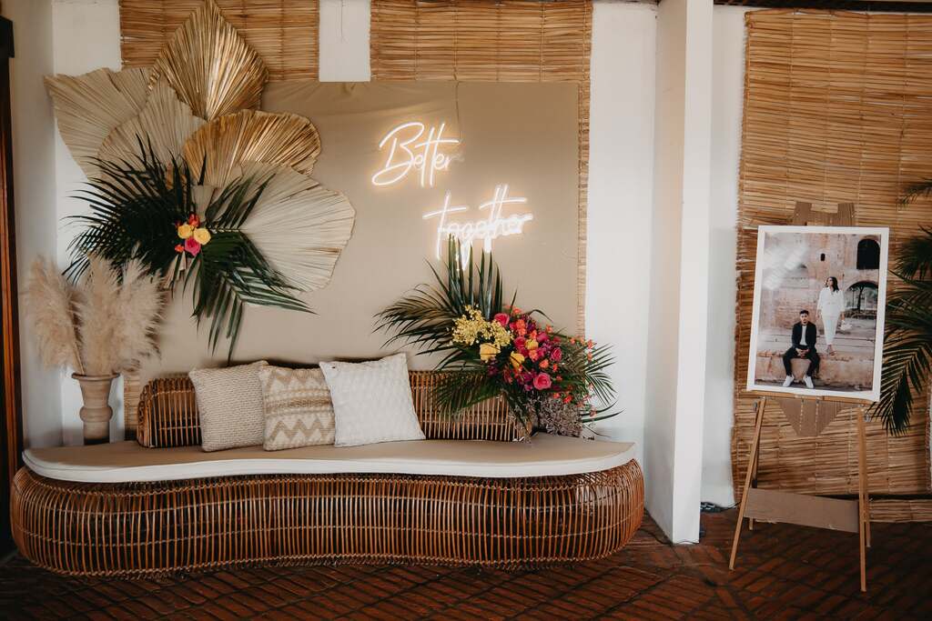 salão decorado com decor boho com sofá de bambu com almofadas com estampas étnicas 