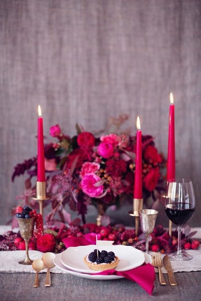 mesa posta com flores e velas na cor fucsia e vermelhas