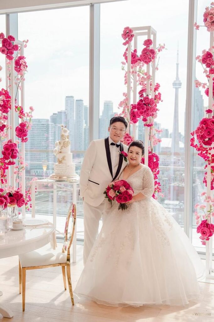 casal plus sie abraçados em salão moderno decorado com paleta de cores fúcsia e branco para casamento