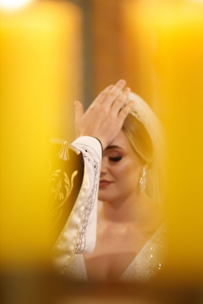 padre colocando a mão na testa da noiva durante oração
