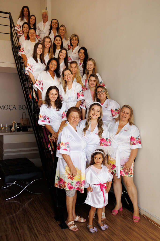 noiva daminha e madrinhas com robes brancos personalizadas com estampa floral na escada