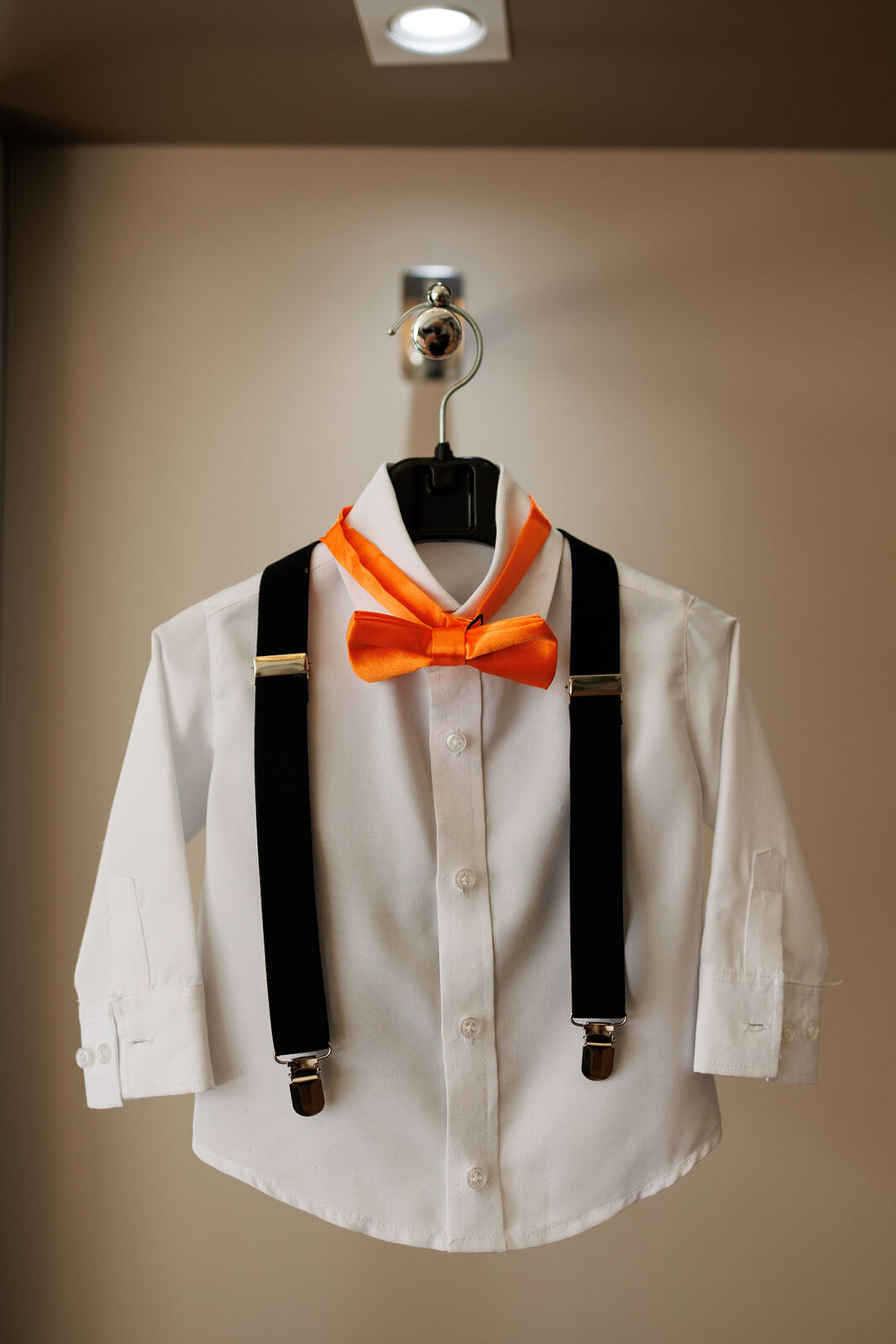 camisa branca e suspensório preto e gravata borboleta laranja para pajem