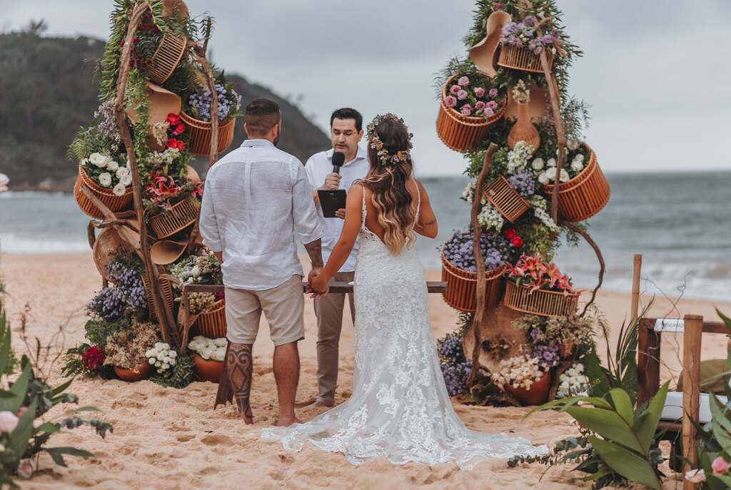 noivos de mãos dadas no casamento na praia