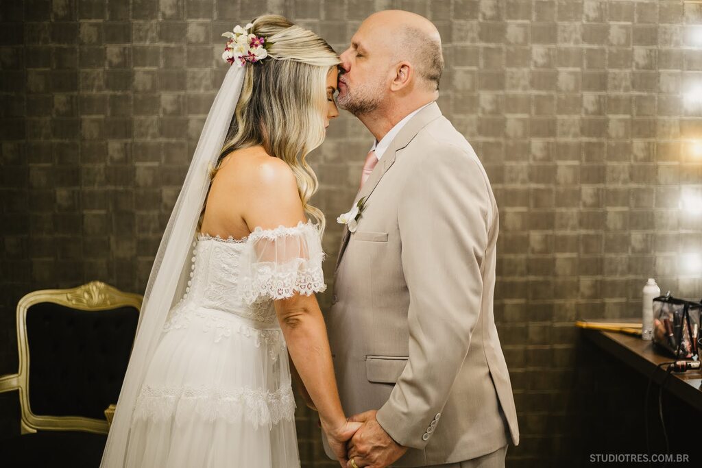 pai da noiva com terno cinza beijandoa testa da noiva