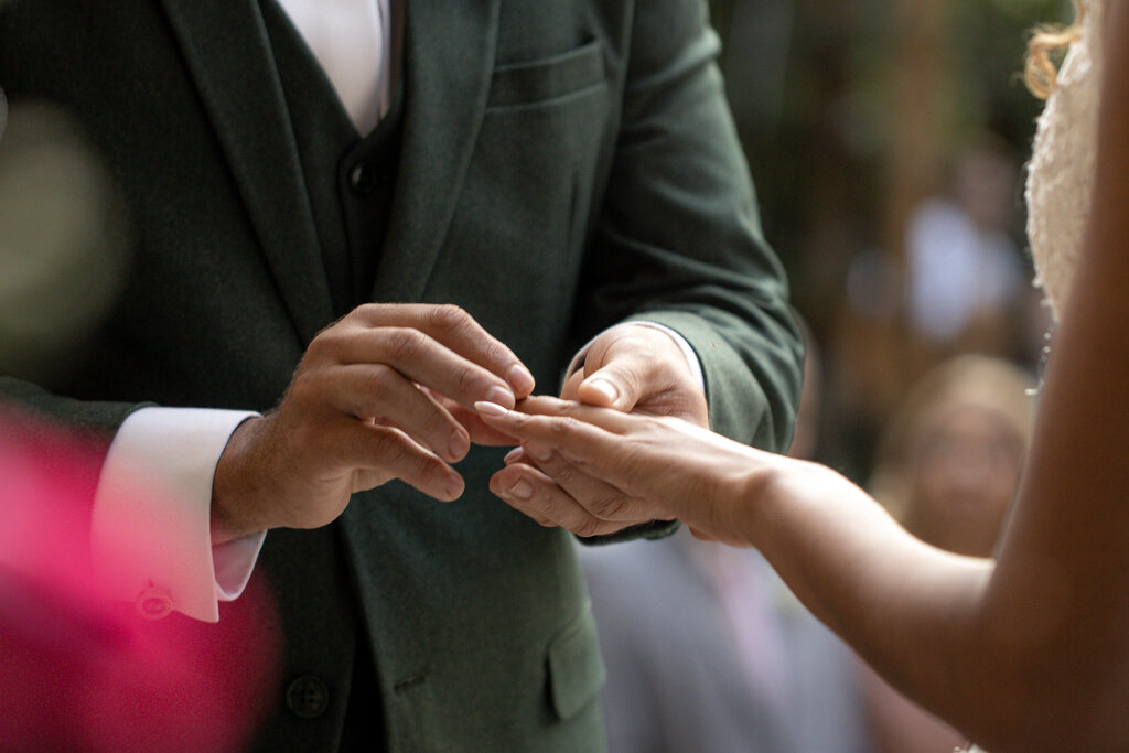 noivo colocando aliança na mão da noiva